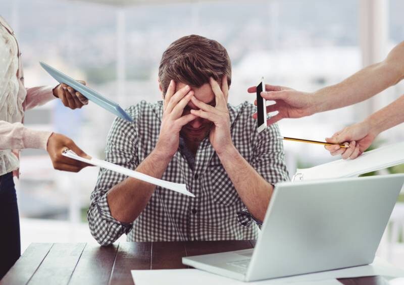 Personne stressée au travail submergée par les sollicitations — situation typique où la respiration profonde aide